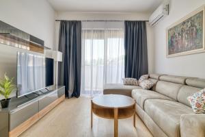 a living room with a couch and a tv at Twin Towers LT Luxury in Becici