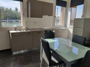 a kitchen with a table with chairs and a refrigerator at Ca' Otto Velieri in Sottomarina