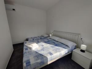 a bedroom with a bed with a blue and white blanket at Ca' Otto Velieri in Sottomarina +27 photos