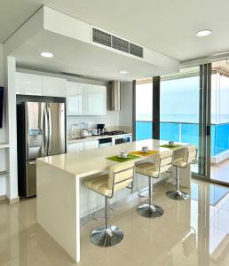 a kitchen with a large island with bar stools at Samaria Top Penthouse Frente al Mar in Gaira