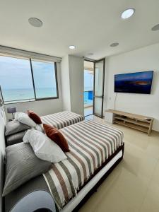 a bedroom with two beds and a flat screen tv at Samaria Top Penthouse Frente al Mar in Gaira +39 photos