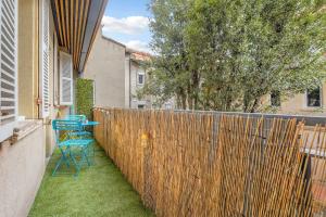 a patio with a blue table and a fence at Le Capitole - Hyper Centre - Cosy - WIFI in Toulouse