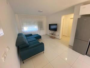 a living room with a blue couch and a television at Guest House Ana Residence in Zadar