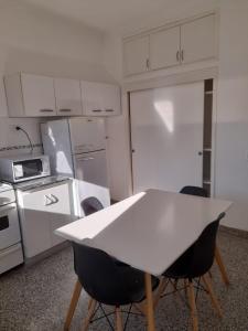 a kitchen with a white table and chairs in it at Depto Centrico en Planta Alta in Bahía Blanca