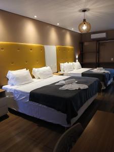 two beds in a hotel room with two bedsvisor at Hotel Summer Beach Paripueira in Paripueira +17 photos