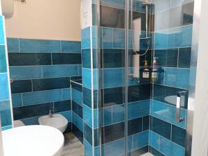 un bagno piastrellato blu con un water e un lavandino di Alghero Escape ad Alghero