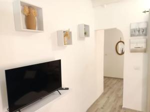 una TV a schermo piatto su una parete bianca con immagini di Alghero Escape ad Alghero
