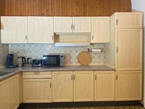 a kitchen with wooden cabinets and a microwave at 150 m 5-room Villa 15 min to Düsseldorf in Kaarst +25 photos