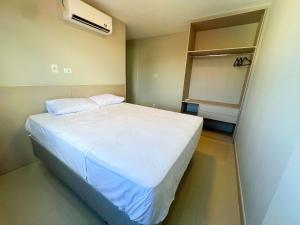 a small bedroom with a white bed and a fan at Luxuoso apê recém reformado na Farolândia in Atalaia Velha +46 photos