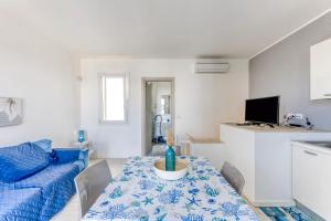 a white living room with a table and a couch at Villetta Alma Maldive Del Salento in Marina di Pescoluse