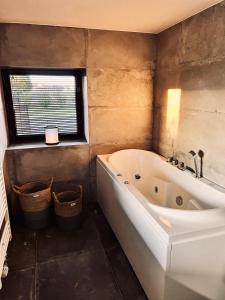 a bathroom with a large tub and a window at Hoeve Molenschot in Molenschot +13 photos