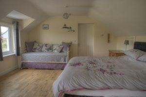 a bedroom with two beds and a couch at Bro Dafydd in Aberystwyth