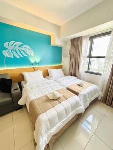 une chambre d'hôtel avec deux lits et un canapé dans l'établissement Good Life Luxury Condo, à Sampong