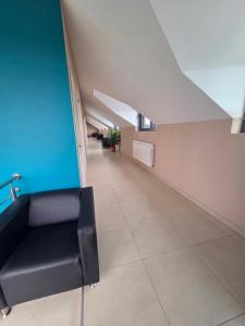 a long hallway with a black couch in a building at Autohof Rekado in Tîrgu Frumos