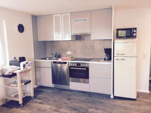 a kitchen with white cabinets and a stainless steel refrigerator at Die 19 in Kappel-Grafenhausen