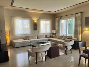 沙姆沙伊赫Luxury Beach Villa With Private Pool的客厅里有一张沙发、一张桌子和几把椅子。