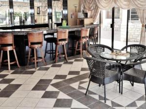 a bar with a checkered floor and tables and chairs at Lakefield Hotel in Benoni