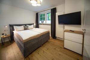 a bedroom with a bed and a flat screen tv at Winkelschiffchen V im Ortszentrum Juist in Juist