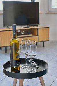 a bottle of wine and two wine glasses on a table at Villa Ante Apartments in Blace