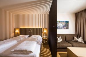una camera da letto con un letto grande e un divano di feel good Resort a Krumpendorf am Wörthersee