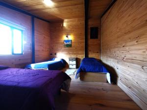 twee bedden in een kamer met houten wanden bij La Horqueta in Malargüe +16 foto's