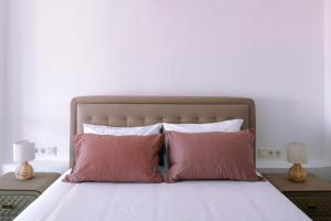 a bed with two pink pillows and a white wall at Diamond Deluxe Loft in Iraklitsa +48 photos