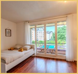 a bedroom with a bed and a large window at Le Cyclade I Studio I Saint-Julien in Saint-Julien-en-Genevois +24 photos