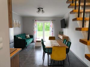 a kitchen and living room with a table and chairs at Apartamenty LilaRóż in Brzozie Polskie