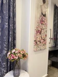 a vase with flowers on a stool next to a painting at Alsago Lux in Sesvete +45 photos