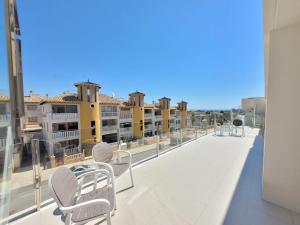 balcón con sillas y vistas a algunos edificios. en Natura Pinet-1, en La Marina