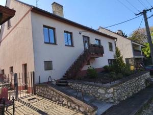 a large white house with a stone wall at Apartma Zlatuška in Pavlov