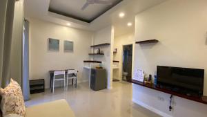a living room with a television and a kitchen with a table at Villa del OZ Resort in Panglao