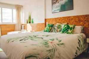 a bedroom with a large bed with green leaves at Apartamento Jacuzzi La Manga - Primera Linea in La Manga del Mar Menor +35 photos