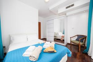 a bedroom with a bed with towels and a mirror at Villa Noulia in Kynopiástai +64 photos