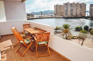 a balcony with a table and chairs and a view of the water at Apartamento Jacuzzi La Manga - Primera Linea in La Manga del Mar Menor
