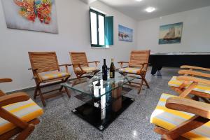 a room with chairs and a table and a piano at Villa Mila in Vela Luka