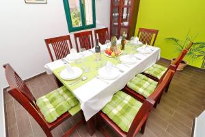 a dining room table with a white table cloth and chairs at Villa Mila in Vela Luka +15 photos