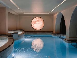 a pool of water in a room with a moon window at DoubleTree by Hilton Malta in St Paul's Bay