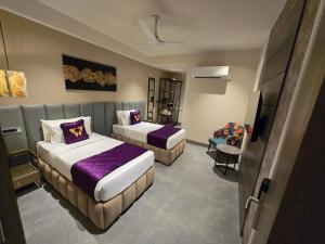 a hotel room with two beds and a television at Western Banjara in Hyderabad