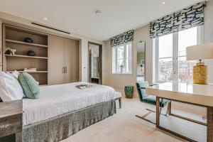 a bedroom with a bed and a desk and window at Westminster Apartments by D'Montrio in London