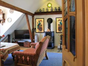 a living room with a couch and a television at Landgasthof und Landhaus Hofmeister in Diemelsee