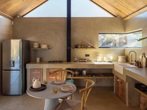 a kitchen with a table and a refrigerator at Ashanté Boutique Retreat in Clanwilliam