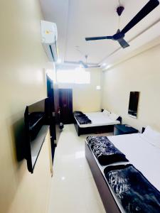 ウッジャインにあるRS Homestayのベッド2台と天井ファンのある部屋