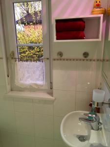 baño con lavabo y ventana en Villa Musica, en Aschau im Chiemgau