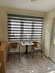 a table and two chairs in a room with a window at Vikendica Lazic in Crnča