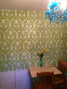 a dining room table with a vase of flowers on a wall at Villa Musica in Aschau im Chiemgau