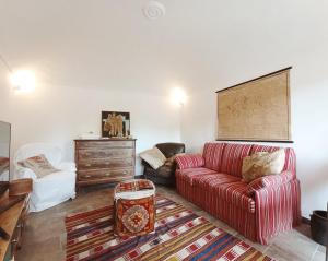 a living room with a red couch and a dresser at Casa Luciana in Chiaverano