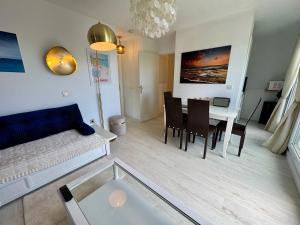 a living room with a couch and a table at La Baule terrasse, piscine, parking tout confort in La Baule