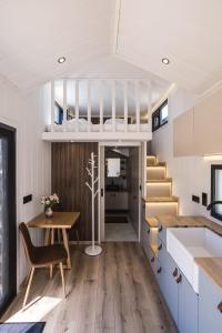a kitchen and dining room with a loft bed in a tiny house at ARIETES MARMONT Tiny Houses in Štrbské Pleso