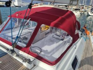 a boat with a red cover on a dock at LUNA BAY, voilier 3 cabines 2 sdb en ville in Sète